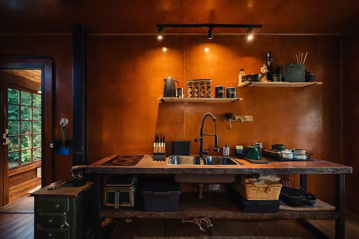 Cozinha equipada da cabana com bancada de madeira e utensílios