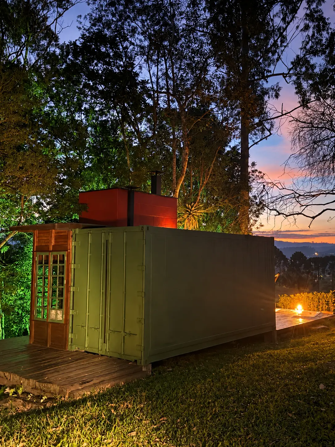 Cabana container do glamping no anoitecer, com luzes acolhedoras