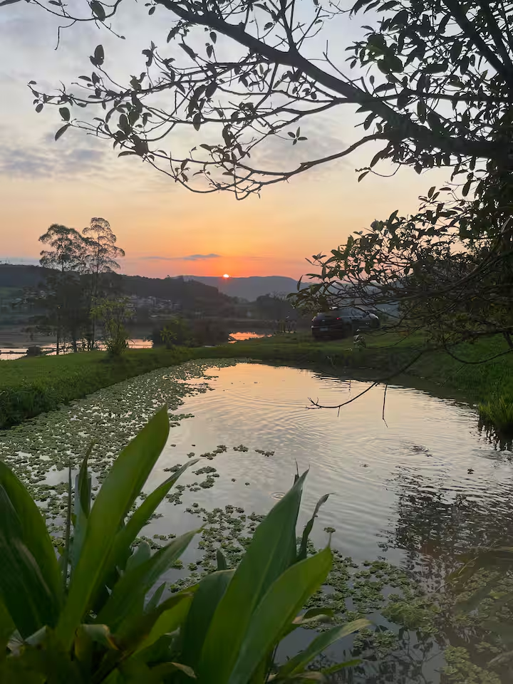 Pôr do sol sobre a lagoa da propriedade do Bela Aliança Glamping